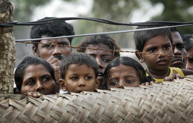 internally_displaced_sri_lankan_tamil_civilians_peep_from_over_a_fence_at_a_camp_for_the_displaced_in_vavuniya.jpg 