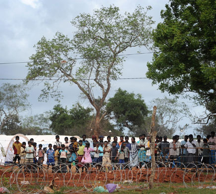 internally_displaced_sri_lankans_wait_behind_barbed_wire_at_menik_farm_refugee_camp.jpg 