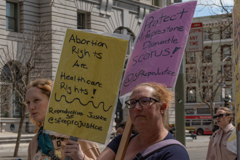 Two women listen to speakers