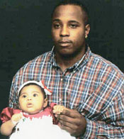 Photo of Cammerin Boyd and his daughter Isabel on her first Christmas