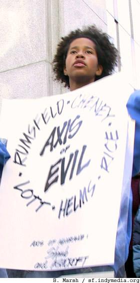 nowar_sf_fed_101102_yng_activist_w_axisofevil_sign.jpg 