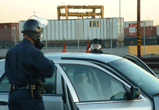 040703_antiwar_oakland_docks_opd_gasmaskoutacar.jpg 