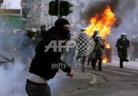 The riot police headquarters in Zografou, Athens were attacked earlier today, with one riot police van and a few cars burnt.nnIndymedia reports that the state-run TV station NET was occupied for a f