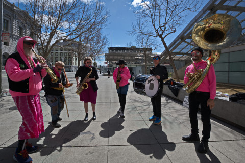 band in pink play sax, tuba, trumpets