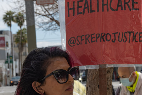 South Asian Demonstrator listens to speakers 