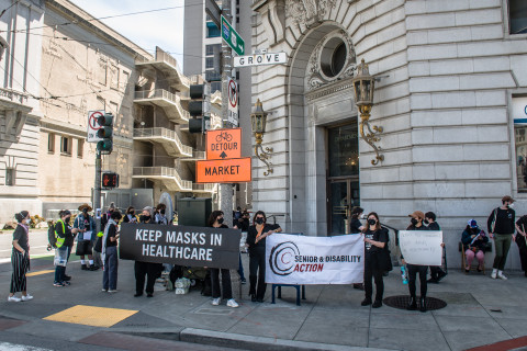 A group of about 25 people standing in front of the Dept of Public Health