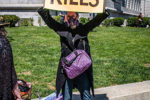 protester with placard SF DPH KILLS