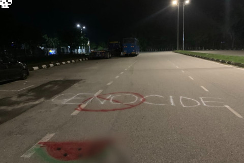 Nighttime photo of a road with pro Palestine spraypainted messages