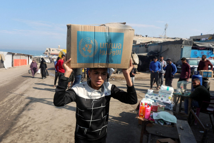 A Palestinian carries an aid box distributed by the United Nations Relief and Works Agency (UNRWA)