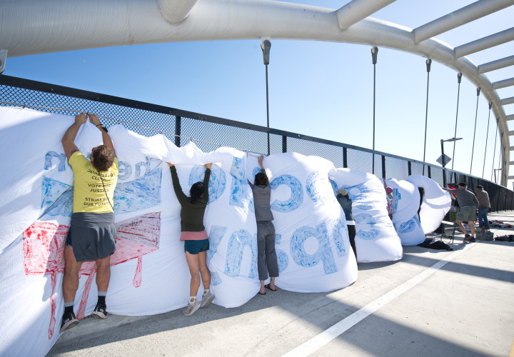 Gigantic Chevron Genocide Banner Deployed Despite High Winds 