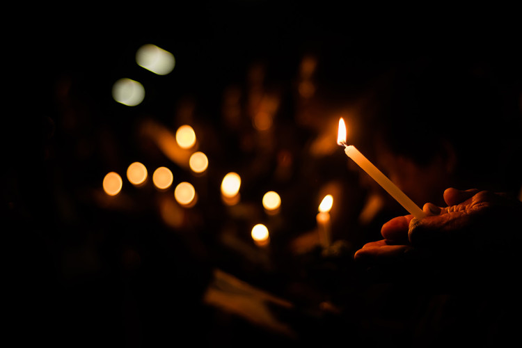 A solemn candlelight vigil at night