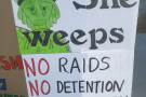 sign with a crying Statue of Liberty that says no raids, no detention, no deportation