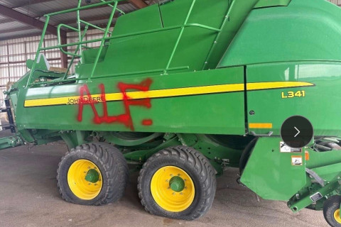 Tractor with flat tires and "ALF" spraypainted on it