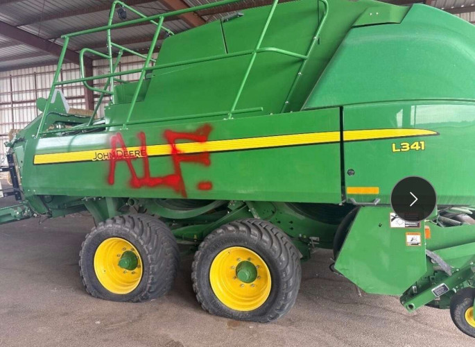 Tractor with flat tires and "ALF" spraypainted on it