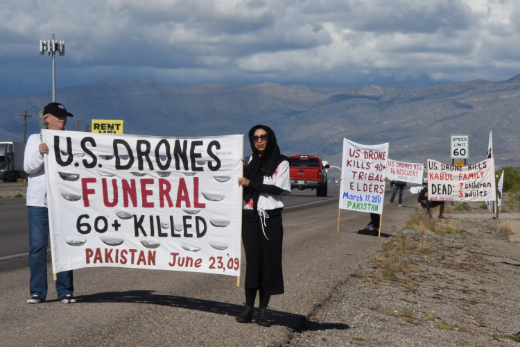 Activists holding banners against drone attacks