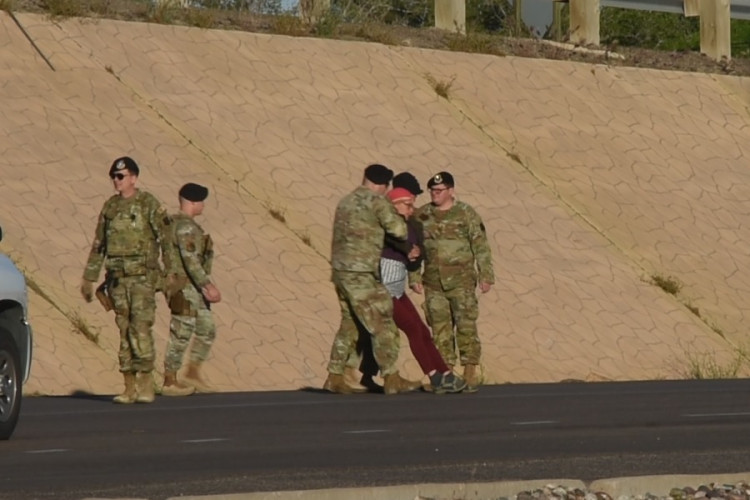 Military police arresting protester in roadway