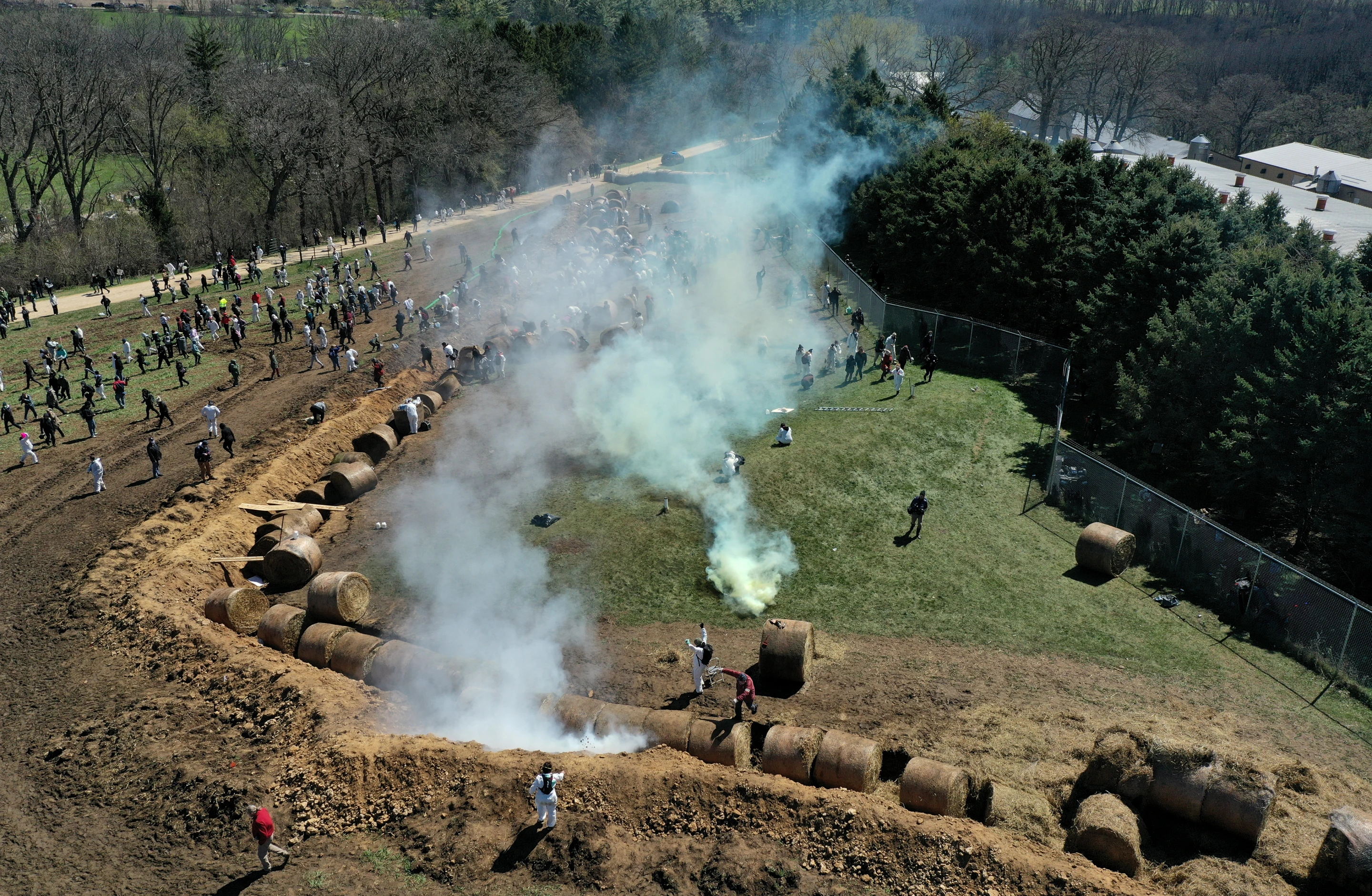 Drone photograph of Ridglan Farms perimeter with activists, moat, and tear gas