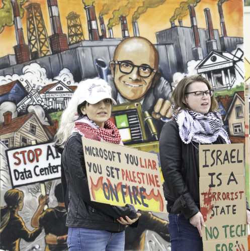 Attendees met by large signs calling out Microsoft's complicity in war crimes and climate devastation