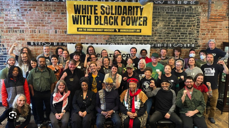 A group of about sixty people assembled under a banner that reads "White Solidarity with Black Power."