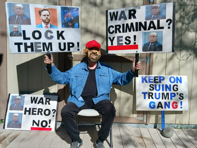 A Utah neighborhood uses garage doors as a backdrop to display signs commenting on the Trump Administration's performance.