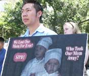 Cau Bich Tran's husband Bao Kim Tran with a photo of their children, demanding justice
