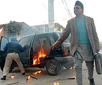 Deputy Auditor General Ghanashyam is forced to walk after protestors torched his official car in Ne